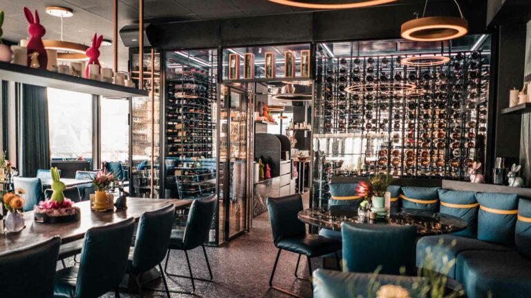 Ansicht SIX ZERO Interieurs mit Tischen, StÃ¼hlen und dekorativen Elementen.