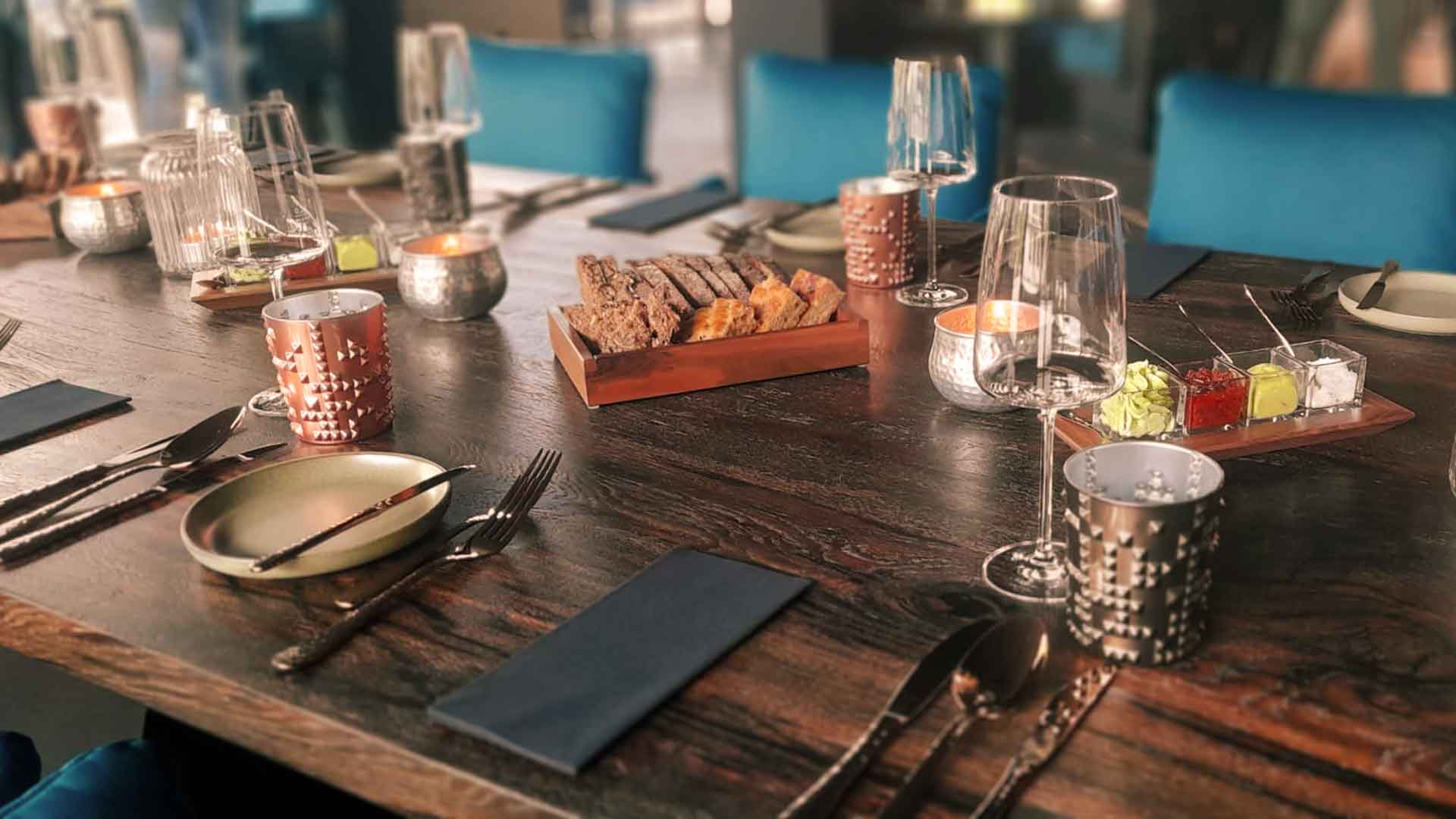 Stilvoll gedeckter Tisch mit Brot, Dips und Kerzen im Restaurant SIX ZERO am Timmendorfer Strand