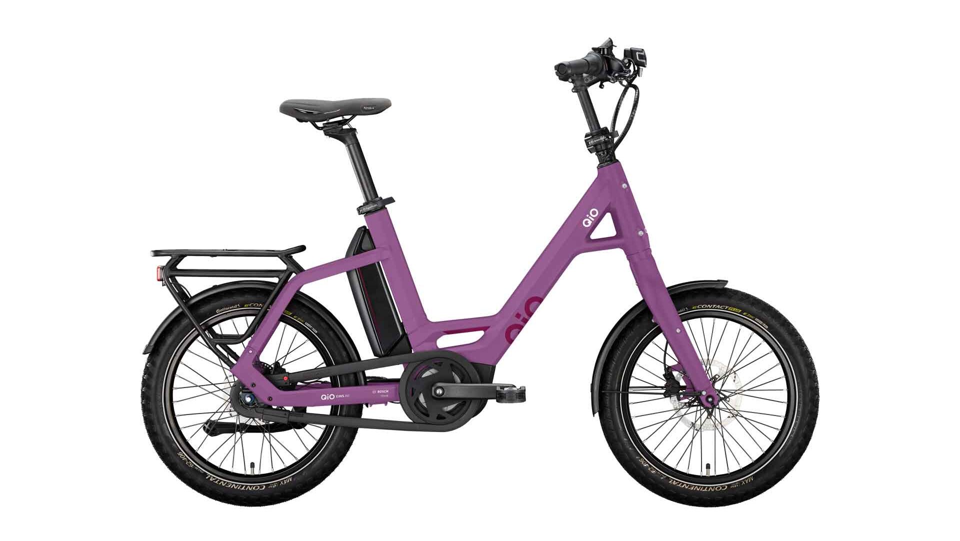 Lila E-Bike mit tiefem Einstieg, dickeren Reifen und Gepäckträger hinten, seitlich fotografiert vor weißem Hintergrund.